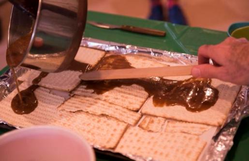 Making Chocolate-Covered Carmelized Matzoh Crunch. Rabbi David Edleson and Director of Education Sarit Katzew lead a Passover Desserts cooking class Havurah House in Middlebury, Vermont. (Caleb Kenna for the Free Press)